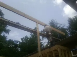 Carpenter setting a ridge beam over a new addition frame — Ice Dam Removal by Roofing Brothers in Thorntown