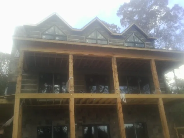 Dormers and porch framing on a large log home under construction — Roof Coating work by our crew in Thorntown