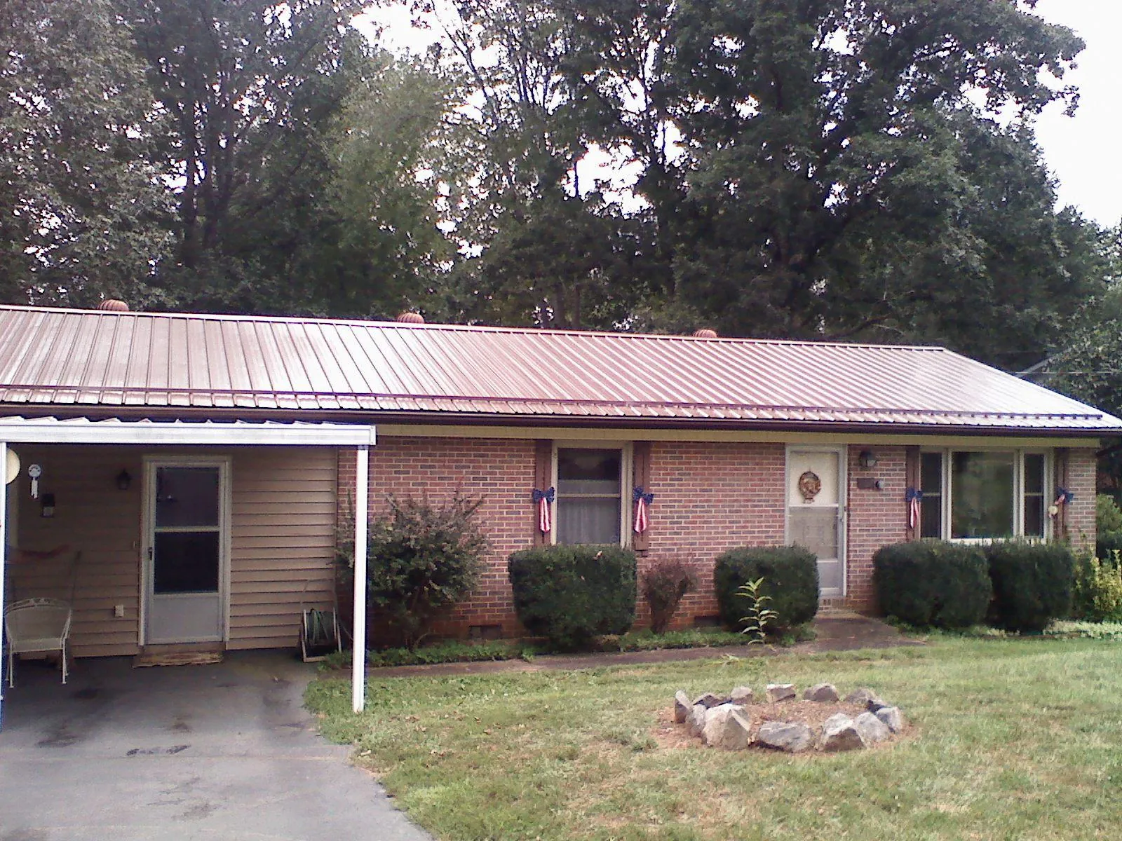Bronze metal roof and carport on a brick ranch home — Roof Repair work by our crew in Thorntown